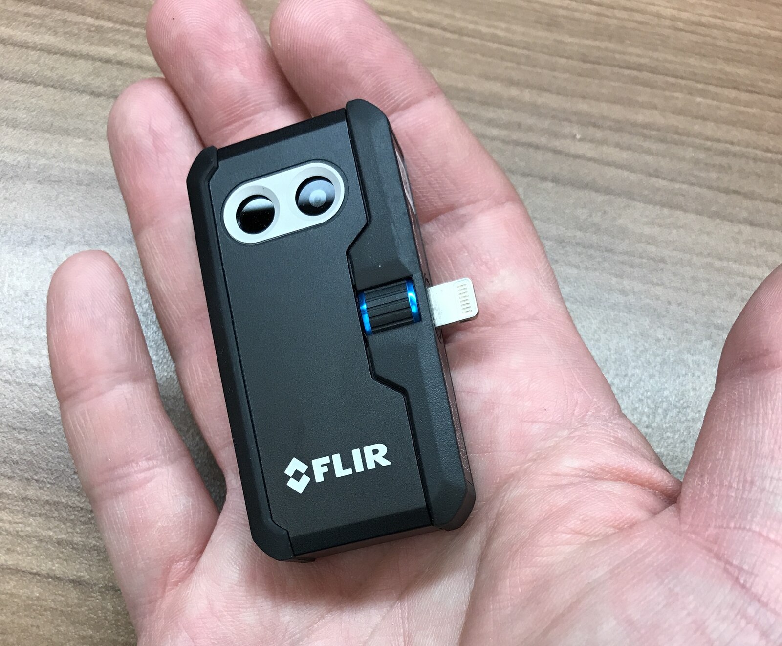 A Lightning-connected FLIR One Pro camera held in a hand